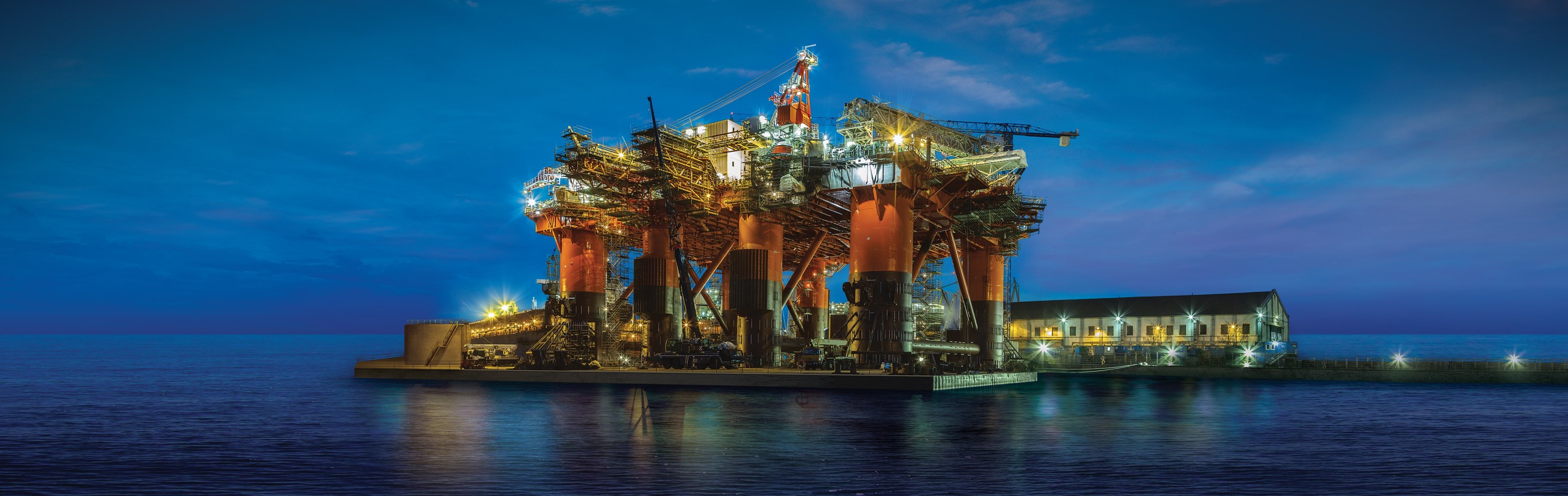 Plataforma en alta mar iluminada en el crepúsculo